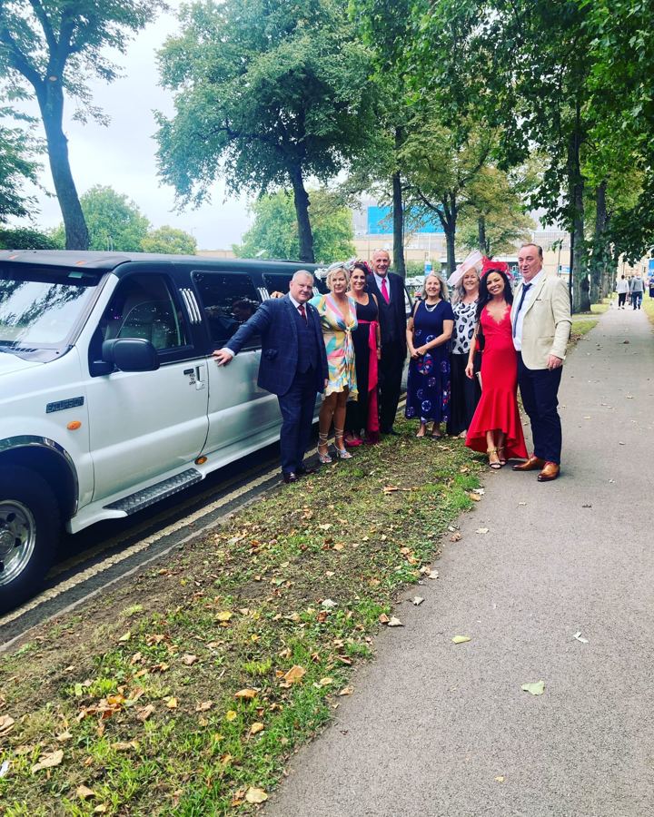 Guests in event outfits beside a white limo, Leicester