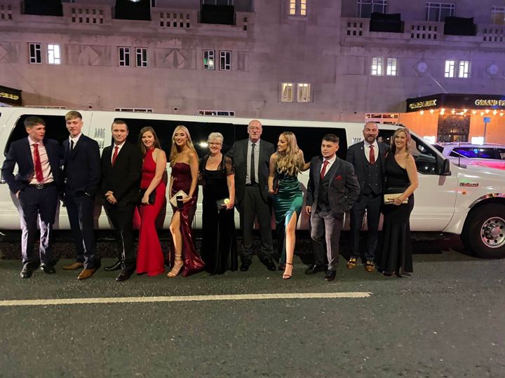 Group in formal wear for a night out in a white limo, Derby