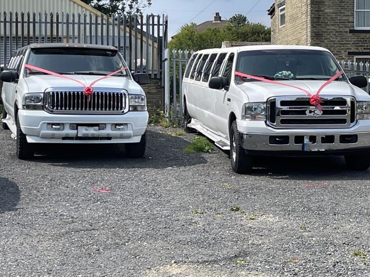 Two white stretch limos dressed with wedding ribbons, Wakefield